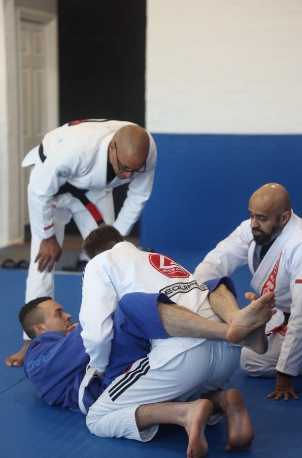 A BJJ student discussing training preferences with a coach, emphasizing open dialogue and exploration